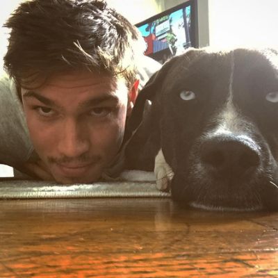 Photo of Tanner Novlan and his dog while staring at the camera. 